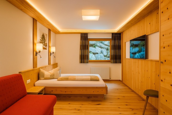 Gemütlicher Raum mit einem Bett und einer Couch, ideal zum Entspannen und Ausruhen.