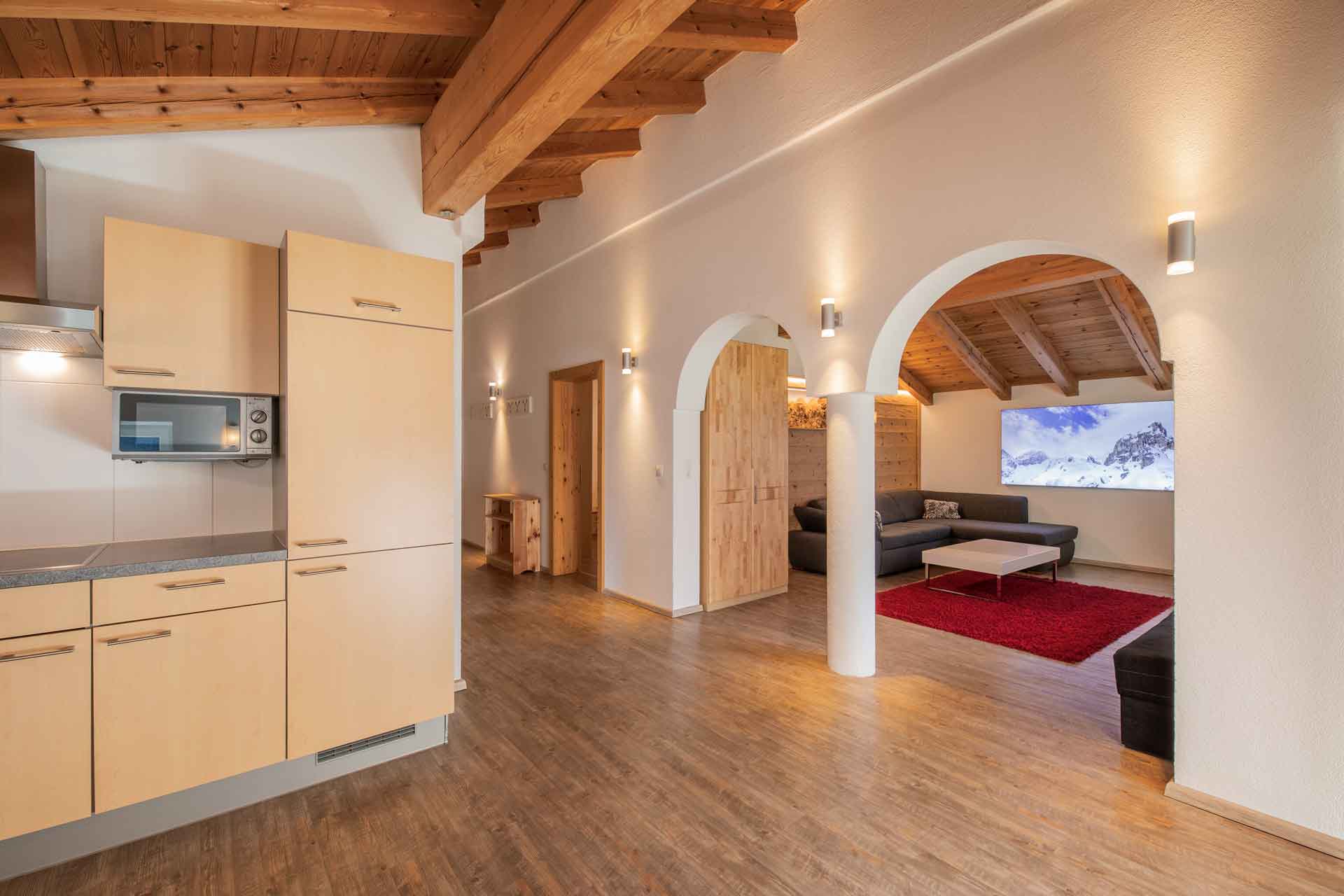 Adlerhorst vacation apartment: Cozy living room in the Adlerhorst vacation apartment with sofa, TV and red carpet. Accommodation in the Stubai Valley, Tyrol.