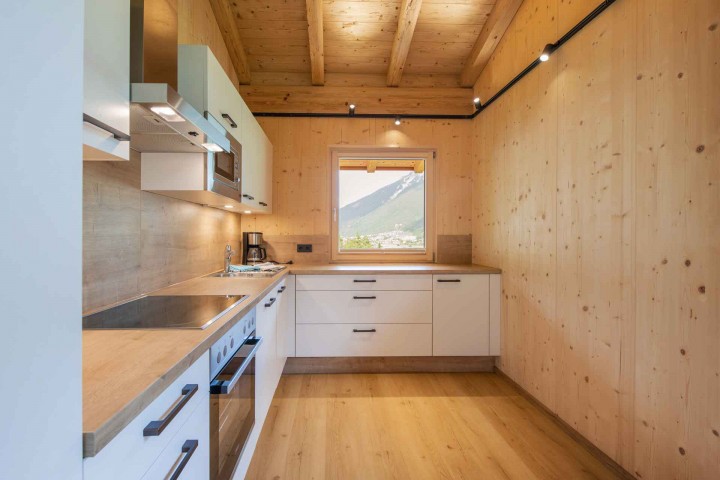 Modern and light-flooded kitchen with stove, sink and coffee machine
