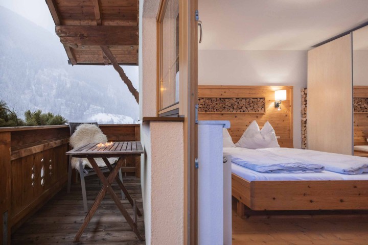 Ein Schlafzimmer mit zwei Betten, ausgestattet mit orange und weißen Bettdecken, vermittelt ein warmes und einladendes Ambiente. Holzdekorelemente.