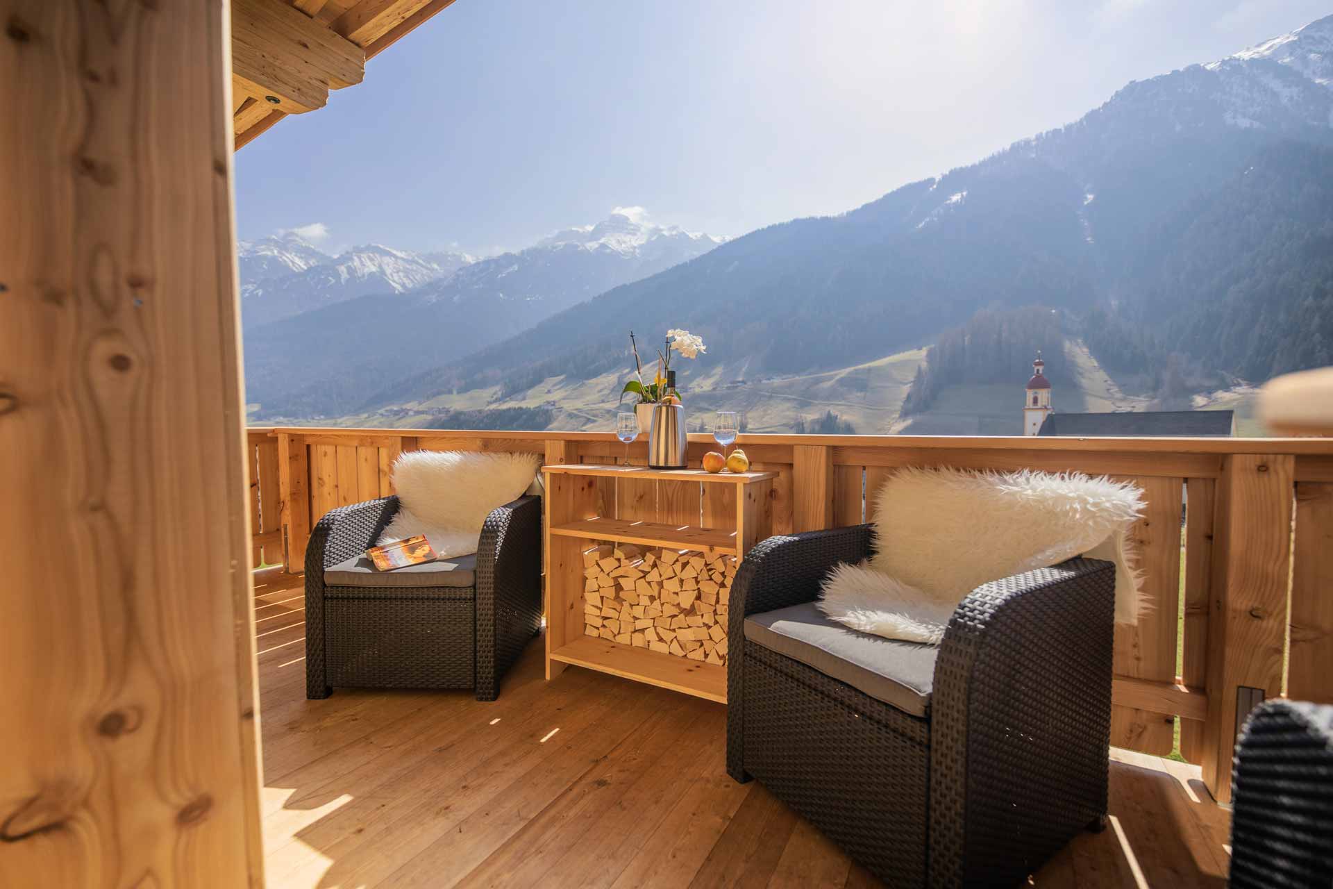 Balcony with woven chairs and views of the impressive mountain landscape.