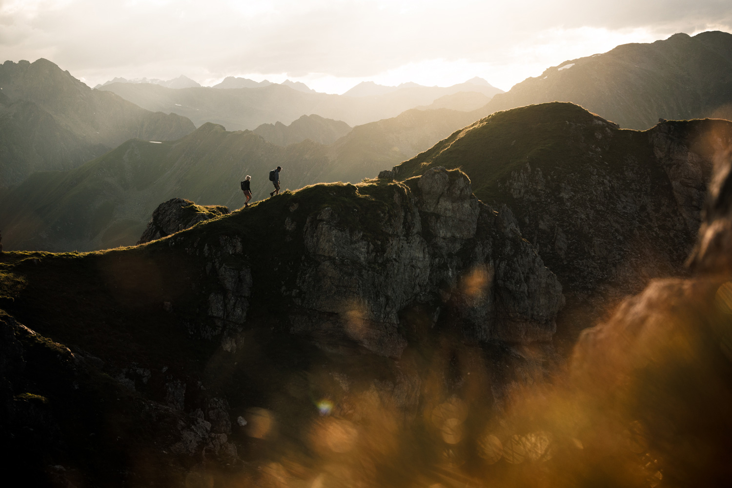 Aerial view of a mountain range with two hikers