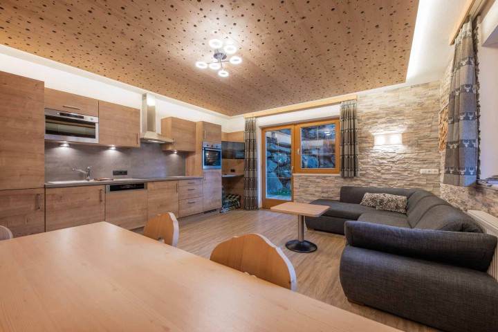 Open plan kitchen and living area in a modern apartment, bright and inviting, with modern furniture and stylish accents.