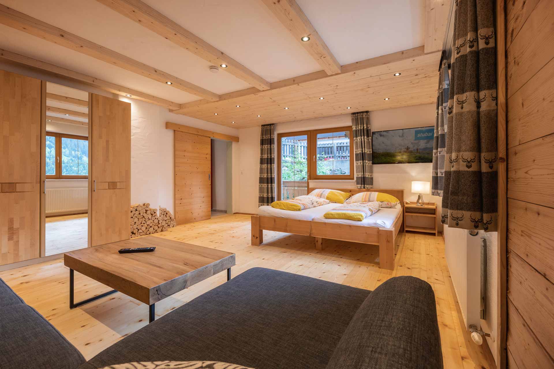 Vacation apartment Morgentau: A stylish bedroom with wood paneling and a comfortable bed that radiates coziness. Accommodation in the Stubai Valley, Tyrol