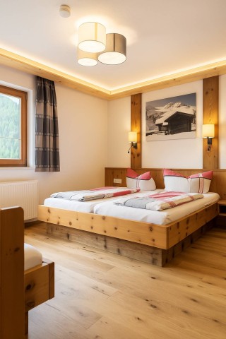 Gemütlicher Raum mit zwei Betten und Zugang zum Balkon, ideal zum Entspannen und Ausruhen.