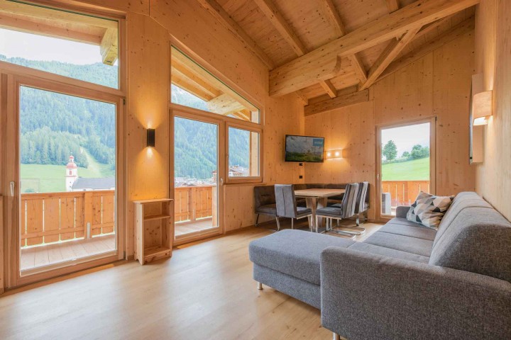 Living and dining area with access to the balcony. Interior design with wood