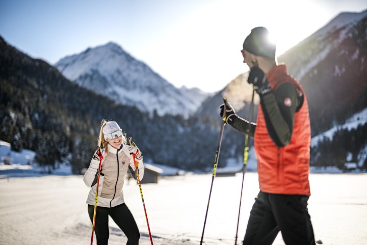 Zwei Personen fahren im Stubaital Langlauf im Schnee und genießen die winterliche Landschaft.