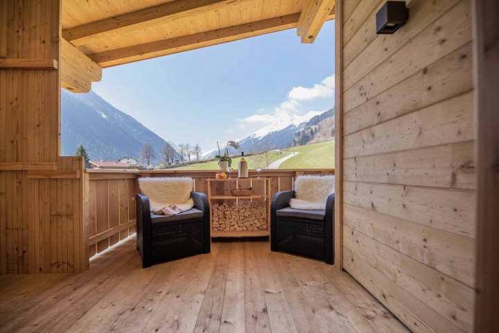 Balcony with woven chairs and views of the impressive mountain landscape.