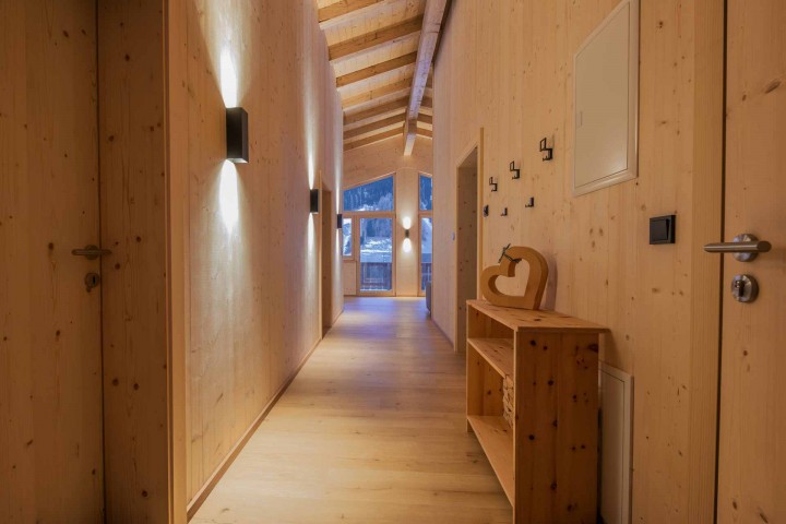 Light-flooded hallway with wooden walls and access to all rooms