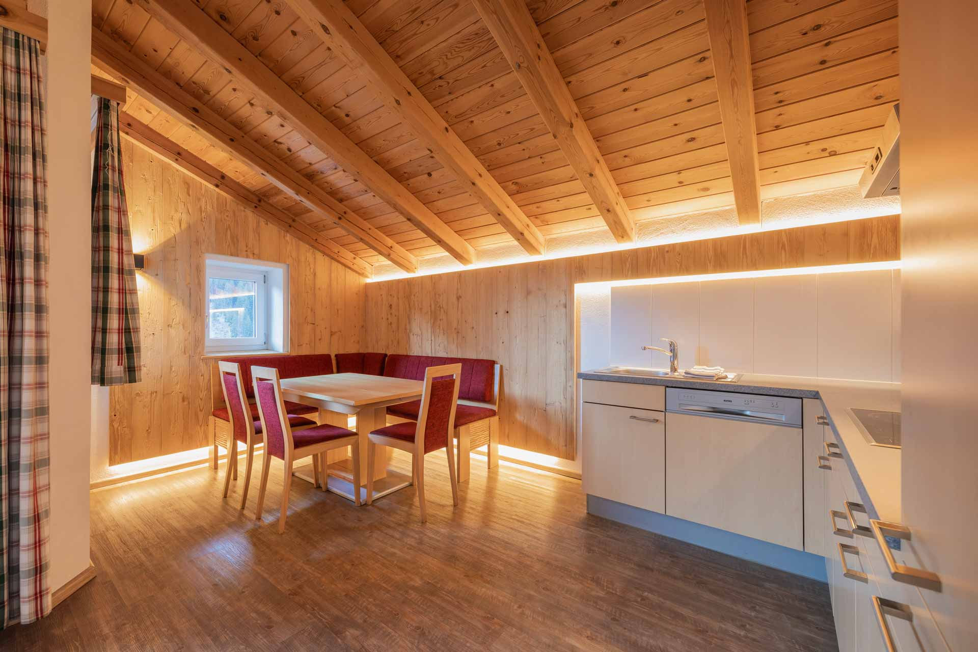 Gemütliches Wohnzimmer mit einem Sofa, einem Tisch und einer Flasche Wein, ideal für entspannte Abende.