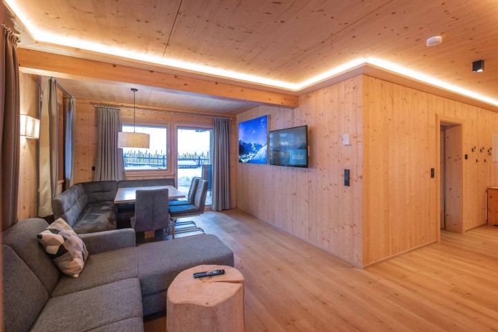 Living and dining area with sofa, table and chairs and access to the balcony