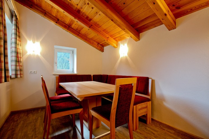 Cozy corner bench with table and chairs and a view of nature