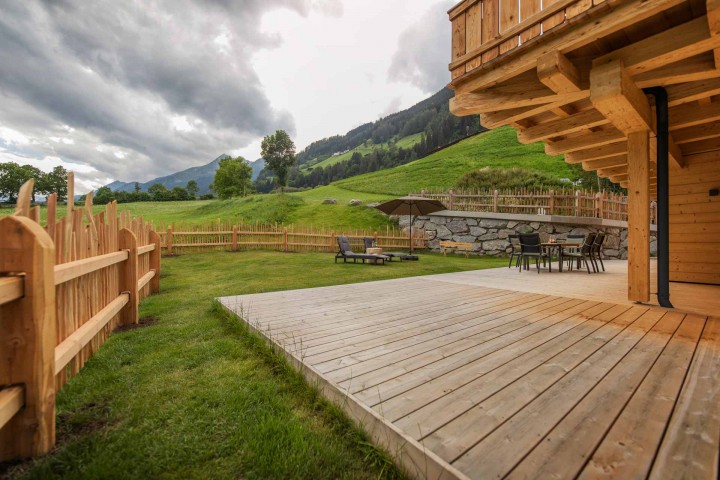 Unterkunft im Stubaital: Das Haus Alpenkönigin in einer verschneiten Umgebung, mit einer Holzterrasse, die zum Entspannen einlädt. 
