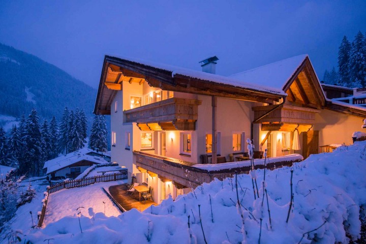 The Alpenkönigin house in the evening. A house in the mountains, surrounded by snow-covered ground and a picturesque winter landscape.