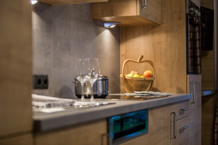 A modern kitchen with fresh apples, a pot on the stove and wine glasses for toasting on vacation